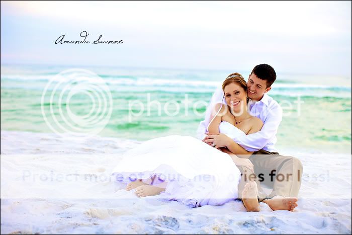 bride and groom sitting in the sand